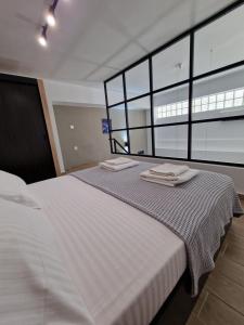 a bedroom with a bed with two towels on it at SKG City Loft in Thessaloniki