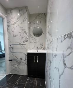 baño con lavabo y pared de mármol en Lovely apartment for 2 or 4 people - Bermondsey en Londres