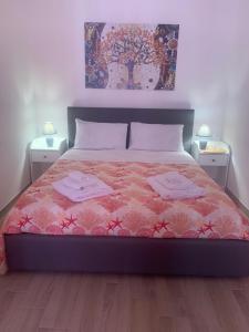 a bedroom with a bed with two towels on it at Holidays Apartment in Cagliari