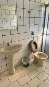 a bathroom with a toilet and a sink at Pousada Navegantes in Pôrto Albuquerque
