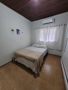 a small bedroom with a bed and a window at Ingá Hospedagem in Porto Velho