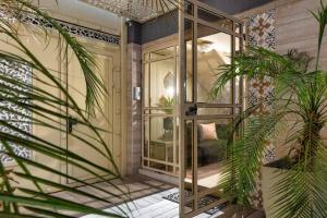 Habitación con puertas de cristal y palmeras. en By Eezy - דירת סטודיו מסוגננת במיקום מעולה באילת Ashram 5, en Eilat