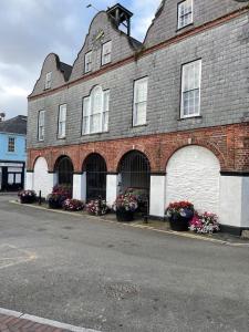 a large brick building with flower pots in front of it at Heart of kinsale in Kinsale