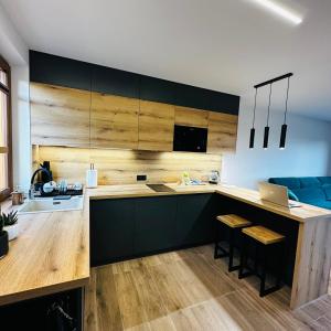 eine Küche mit Holzschränken und eine Küche mit einem Laptop in der Unterkunft Domki pod Luboniem in Rabka-Zdrój
