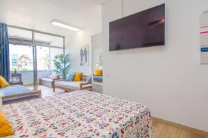 a bedroom with a bed and a tv on a wall at ABC - Apartment Beach & City + Balcony 6m2 in Las Palmas de Gran Canaria