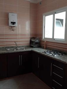 a kitchen with a sink and a window at Appartments Achahbar in Al Hoceïma