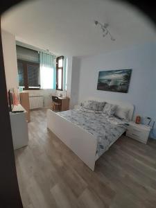 a white bedroom with a large bed and a desk at Lake View in Constanţa