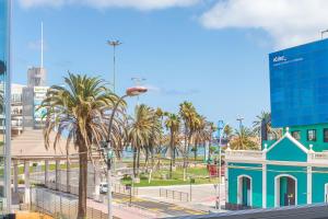 a view of a city with palm trees and a blue building at ABC - Apartment Beach & City + Balcony 6m2 in Las Palmas de Gran Canaria