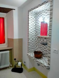 uma casa de banho com um lavatório e uma janela em La casa di Mastro Ivetto em Arcevia