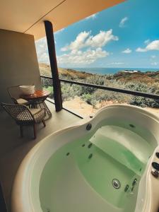 a bath tub in a room with a view of the desert at Miragem Noronha in Fernando de Noronha