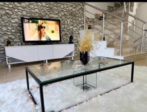 a living room with a glass table and a tv at Antalya Manavgat in Manavgat