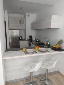 a kitchen with two chairs and a counter with plates at Apartament Bałtycka in Kołobrzeg
