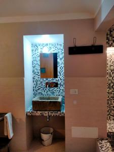 La salle de bains est pourvue d'un lavabo et d'un miroir. dans l'établissement La casa di Mastro Ivetto, à Arcevia