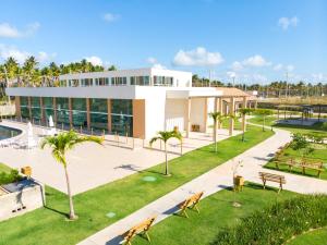 ein Gebäude mit einem Park davor in der Unterkunft Muro Alto Condomínio Clube in Porto De Galinhas