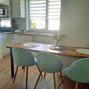 uma cozinha com uma mesa de madeira e 4 cadeiras em Imperium Residence em Sfîntu Ilie