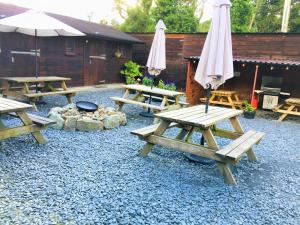 un gruppo di tavoli da picnic e ombrelloni in un cortile di Private Room at Torrent Walk Bunkhouse in Snowdonia a Dolgellau