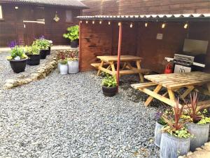 a patio with two picnic tables and potted plants at Private Heated Bedrooms at The Bunkhouse in Snowdonia Perfect for Bikers and Walkers in Dolgellau