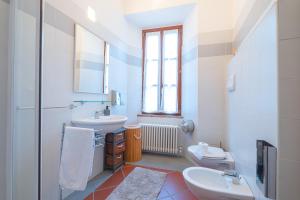 a white bathroom with a sink and a toilet at Veleia Romana B&B in Rustigazzo