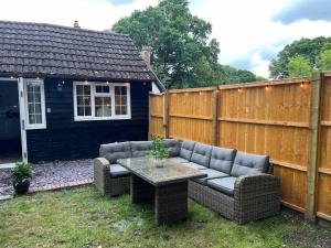 a backyard with a couch and a table and a fence at Hot Tub hideaway! New Forest in Cadnam
