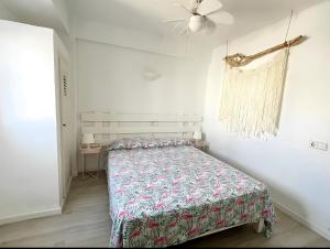 1 dormitorio con 1 cama y ventilador de techo en Apartamentos Formentera Copacabana 18, en Es Pujols