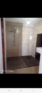 łazienka z prysznicem i ścianą wyłożoną kafelkami. w obiekcie Cisarska sadyba w mieście Świtaź