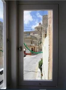 a window with a view of a city street at Townhouse Twenty in Żebbuġ