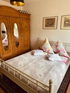 een slaapkamer met een bed met een houten dressoir en spiegels bij Ferienwohnung Landhaus in Zurow