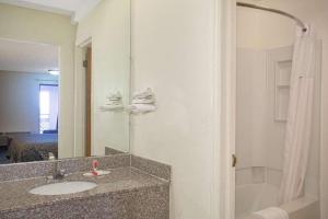 Economy Hotel Wichita 2 في ويتشيتا: حمام مع حوض ومرآة