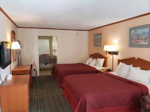 a hotel room with two beds and a television at Economy Hotel Wichita 2 in Wichita