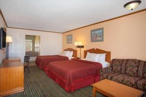 Economy Hotel Wichita 2 في ويتشيتا: غرفة فندقية بسريرين واريكة