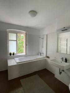 a bathroom with a tub and a sink and a window at Luxurious Penthouse - Berlin Mitte (Center of Berlin) in Berlin