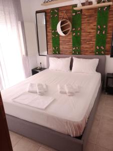 a bedroom with a large bed with two towels on it at Serres Kavafi 7 city center , FREE PARKING , FREE NETFLIX in Serres