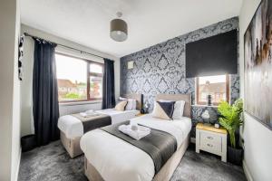 een slaapkamer met 2 bedden en een raam bij LOW RATE - Coventry for 3 BedRoom House with Garden, FREE Netflix and Unlimited Wi-fi - Driveway Parking - AGC in Coventry