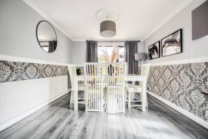 sala de estar con sillas blancas y mesa en LOW RATE - Coventry for 3 BedRoom House with Garden, FREE Netflix and Unlimited Wi-fi - Driveway Parking - AGC, en Coventry
