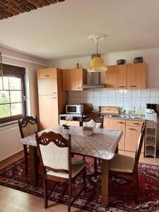 a kitchen with a table and some chairs and a table and a kitchen at Ferienwohnung Landhaus in Zurow