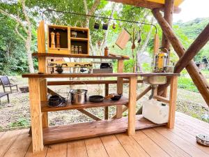 una mesa de madera en una terraza de madera con cocina en RAINBOW FOREST Permaculture filed - Vacation STAY 78984v, en Ibaruma