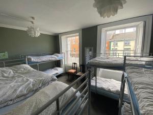 a room with three bunk beds and a window at Kilkenny Tourist Hostel in Kilkenny