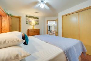 a bedroom with a large white bed with a ceiling fan at Fredericksburg Retreat with Private Hot Tub and Patio! in Fredericksburg