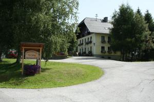 a sign in front of a house with a building at Ferienwohnungen Bachergut in Mariapfarr