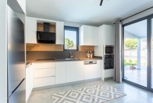 a kitchen with white cabinets and a large window at Villa Exclusive Paradise 1 in Dalyan