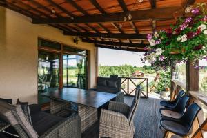 a screened in porch with a table and chairs at Sodyba Gintaras in Priekulė