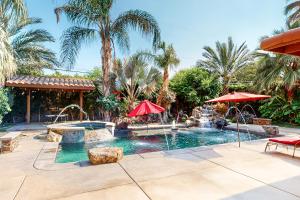 a swimming pool with a fountain in a yard with palm trees at Fred Waring Dreams in Palm Desert