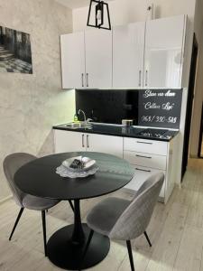 a kitchen with a table and chairs in a kitchen at Lux Cotton in Podgorica +4 photos