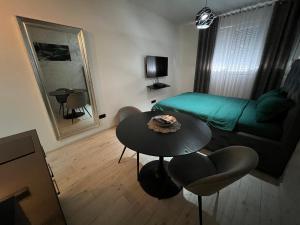 a living room with a table and a green couch at Lux Cotton in Podgorica