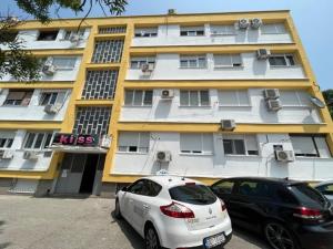 two cars parked in front of a building at Lux Cotton in Podgorica
