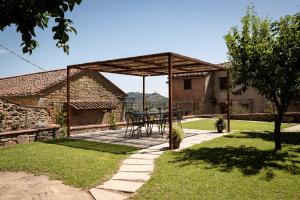 a patio with a table and bench in a yard at Casa La Girandola in Castiglion Fiorentino