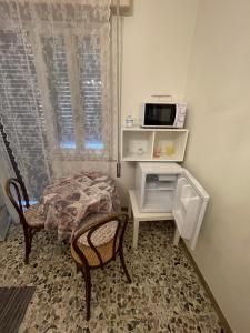 Kleines Zimmer mit einem Tisch und einer Mikrowelle. in der Unterkunft Romantik Zimmer in Potenza Picena