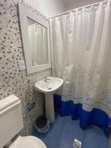 Un baño con lavabo, inodoro y espejo. en Cabañas Luján, en Potrero de los Funes