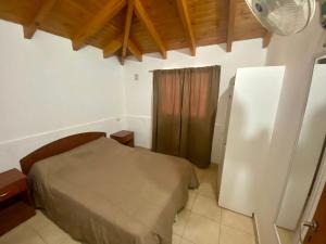 Un dormitorio pequeño con una cama y una ventana. en Cabañas Luján, en Potrero de los Funes 26 fotos más