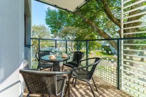a patio with chairs and a table on a balcony at Sunset Vibes Apartment in Kołobrzeg